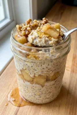 Close-up of overnight oats topped with apples, yogurt, walnuts, and honey.