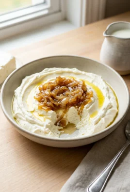 Close up of creamy whipped feta dip in a rustic bowl with pita bread.