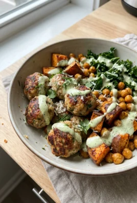 A colorful chicken meatball bowl seen from the side, showing all the layers and textures of the dish.