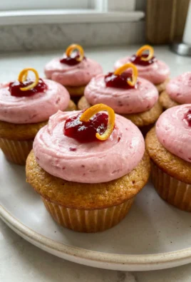 Several cranberry orange cupcakes arranged on a white plate, ready to be served.